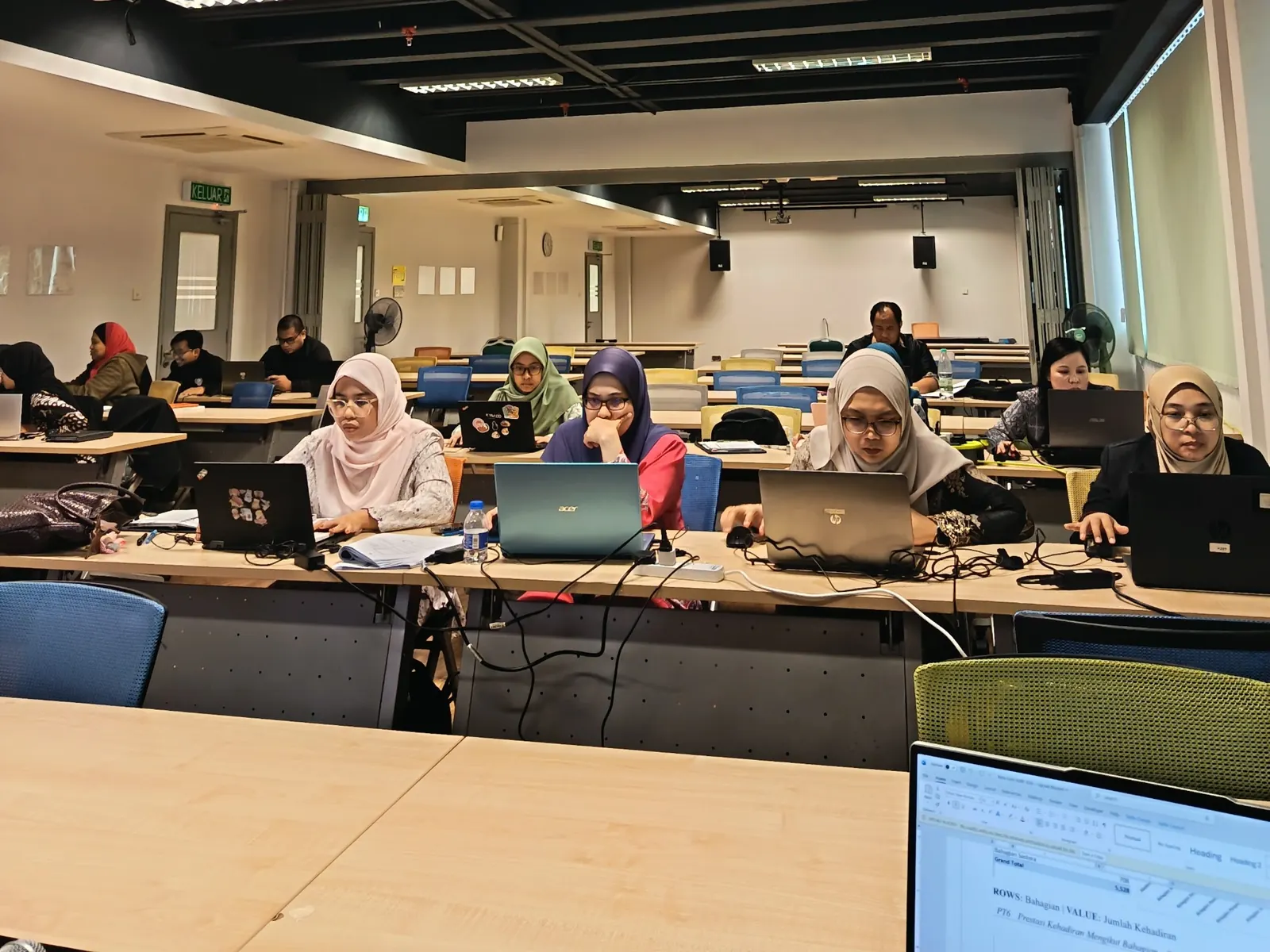 Peserta bekerja dengan komputer semasa latihan